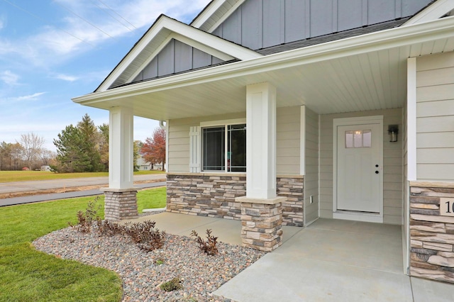 17769 Hoover St NW, Elk River, MN 55330 - doorway to property featuring a porch, board and batten siding, stone siding, and a yard