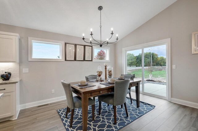 17769 Hoover St NW, Elk River, MN 55330 - dining area featuring a chandelier, plenty of natural light, light wood-style flooring, vaulted ceiling, and baseboards