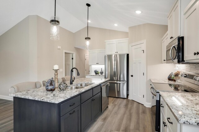 17769 Hoover St NW, Elk River, MN 55330 - kitchen featuring appliances with stainless steel finishes, a sink, white cabinetry, light wood-type flooring, and tasteful backsplash