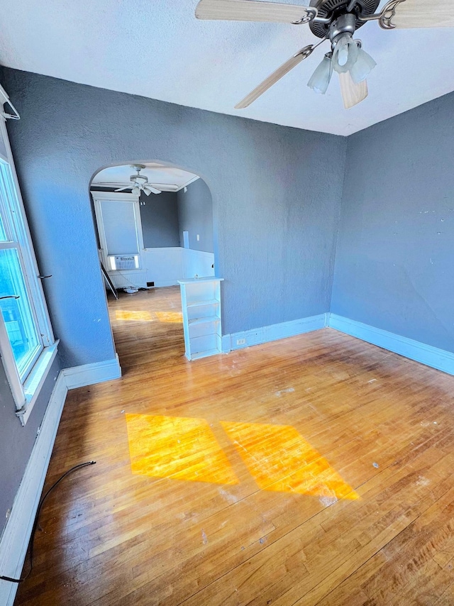 1609 11th Ave S, Minneapolis, MN 55404 - unfurnished room with arched walkways, a ceiling fan, baseboards, wood finished floors, and a textured wall