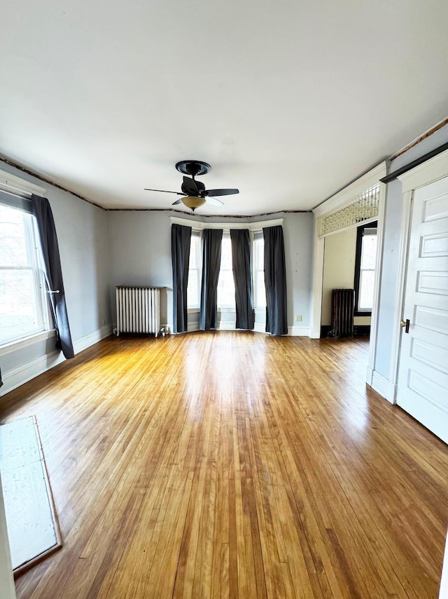 1609 11th Ave S, Minneapolis, MN 55404 - spare room with radiator heating unit, plenty of natural light, wood finished floors, and ceiling fan