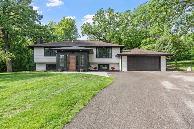 8150 Wildwood Rd, Laketown Twp, MN 55387 - bi-level home with a garage, a chimney, and a front lawn