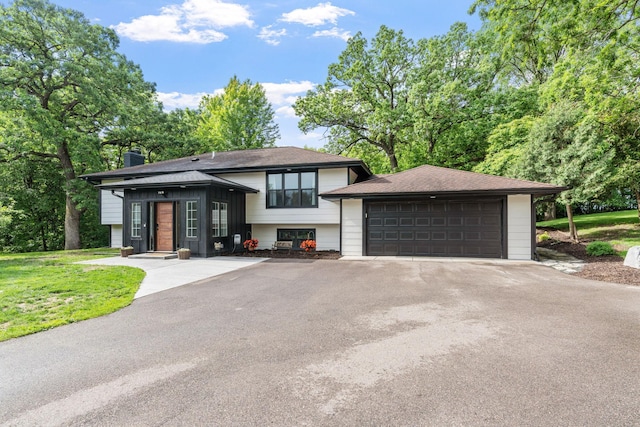 8150 Wildwood Rd, Laketown Twp, MN 55387 - view of front of property featuring a chimney, a garage, a front lawn, and roof with shingles