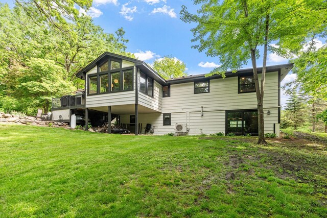 8150 Wildwood Rd, Laketown Twp, MN 55387 - rear view of property with a sunroom, a yard, and a cooling unit