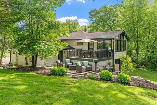 8150 Wildwood Rd, Laketown Twp, MN 55387 - back of house with a patio, roof with shingles, a yard, a sunroom, and a wooden deck