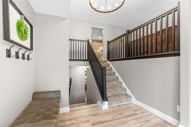 8150 Wildwood Rd, Laketown Twp, MN 55387 - stairway featuring wood finished floors, a chandelier, and baseboards