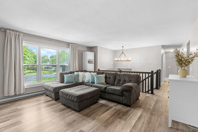 8150 Wildwood Rd, Laketown Twp, MN 55387 - living area with a chandelier, a textured ceiling, light wood-style floors, and a baseboard radiator