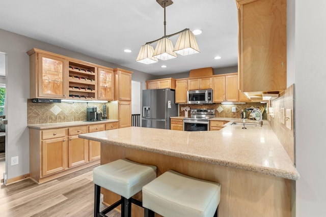 8150 Wildwood Rd, Laketown Twp, MN 55387 - kitchen featuring stainless steel appliances, a sink, a peninsula, decorative backsplash, and recessed lighting