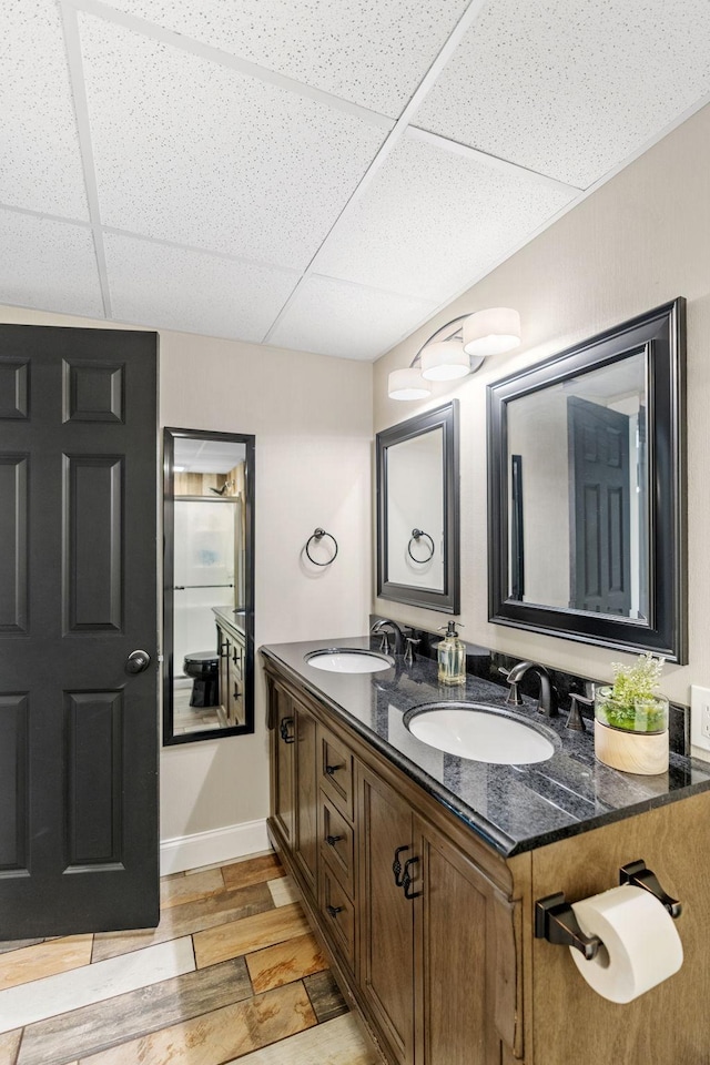8150 Wildwood Rd, Laketown Twp, MN 55387 - full bath featuring a drop ceiling, double vanity, wood finished floors, and baseboards