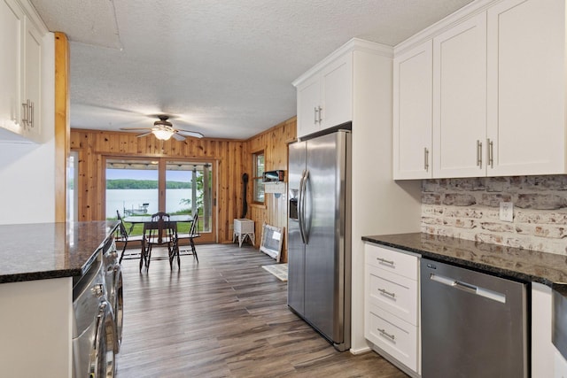 218 9 1/4 Ave, Turtle Lake, WI 54004 - kitchen with appliances with stainless steel finishes, white cabinetry, backsplash, ceiling fan, and wood walls