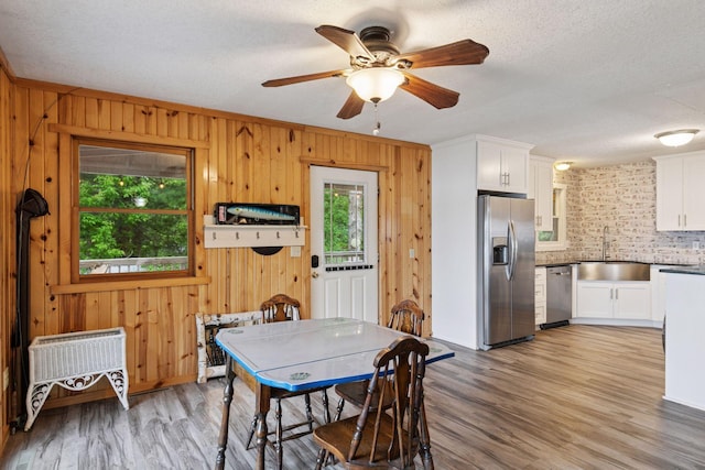 218 9 1/4 Ave, Turtle Lake, WI 54004 - dining room with plenty of natural light, light wood-style flooring, a textured ceiling, wood walls, and a ceiling fan