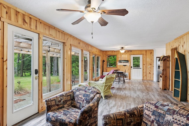 218 9 1/4 Ave, Turtle Lake, WI 54004 - living area featuring plenty of natural light, a ceiling fan, wooden walls, a textured ceiling, and light wood finished floors