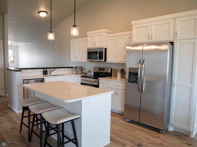 6321 83rd Ave S, Horace, ND 58047 - kitchen featuring stainless steel appliances, a sink, white cabinetry, light wood-type flooring, and high vaulted ceiling