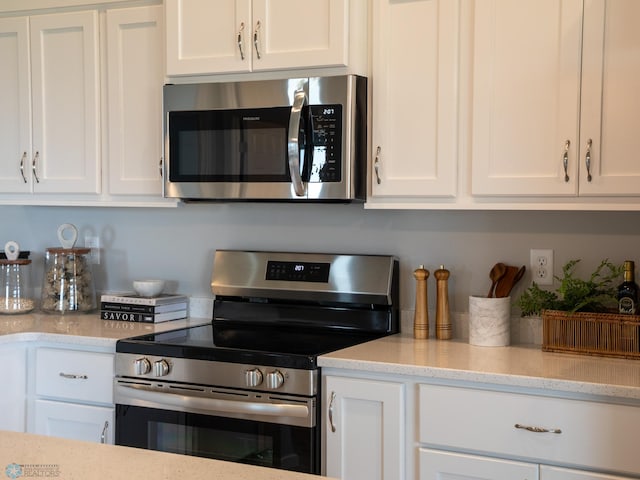6321 83rd Ave S, Horace, ND 58047 - kitchen featuring appliances with stainless steel finishes, white cabinetry, and light stone countertops
