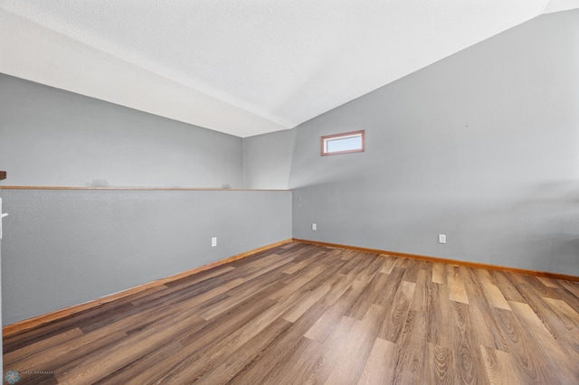 1095 Parkway Ln, West Fargo, ND 58078 - empty room featuring wood finished floors, vaulted ceiling, and baseboards