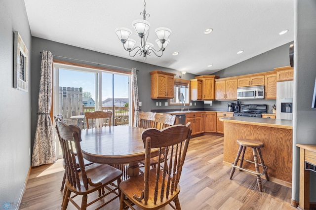 1095 Parkway Ln, West Fargo, ND 58078 - dining room featuring light wood-style flooring, a chandelier, vaulted ceiling, recessed lighting, and baseboards