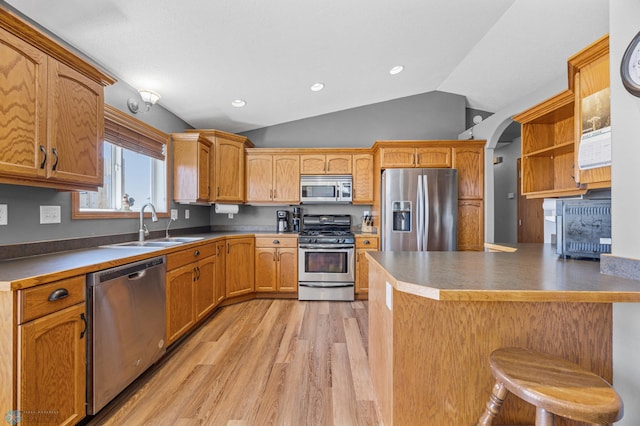 1095 Parkway Ln, West Fargo, ND 58078 - kitchen with stainless steel appliances, a sink, light wood finished floors, a peninsula, and lofted ceiling