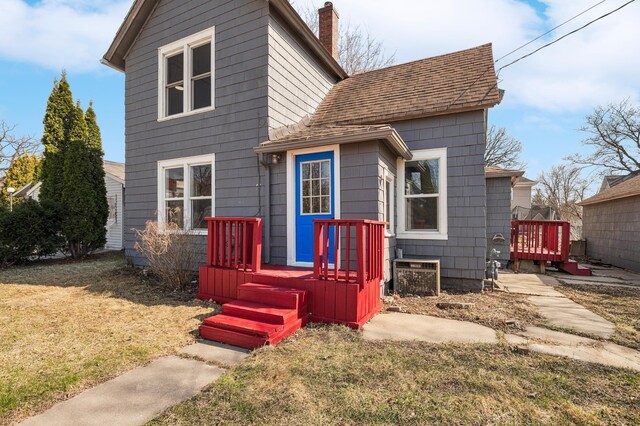 1010 8th Ave NE, Austin, MN 55912 - view of front of home with a front yard, a deck, central AC unit, and a chimney