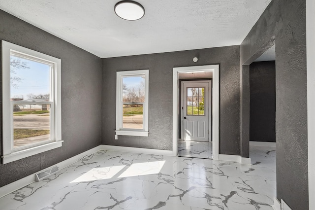 1010 8th Ave NE, Austin, MN 55912 - foyer with a textured wall, baseboards, and marble finish floors