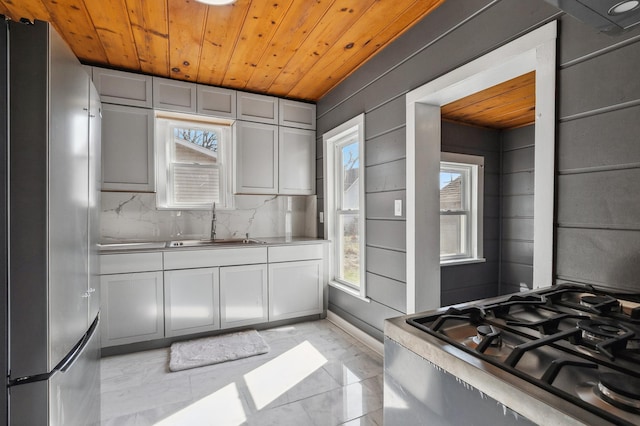 1010 8th Ave NE, Austin, MN 55912 - kitchen with freestanding refrigerator, a sink, wooden ceiling, light marble finish floors, and gas range oven