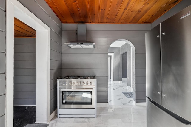 1010 8th Ave NE, Austin, MN 55912 - kitchen featuring appliances with stainless steel finishes, wall chimney range hood, light marble finish flooring, wood ceiling, and arched walkways