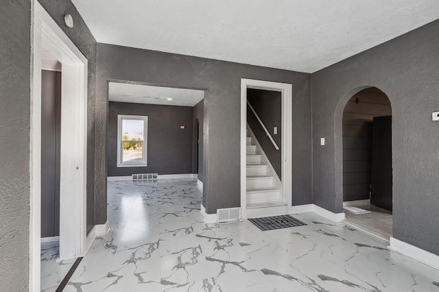 1010 8th Ave NE, Austin, MN 55912 - corridor with a textured wall, arched walkways, baseboards, stairs, and marble finish flooring