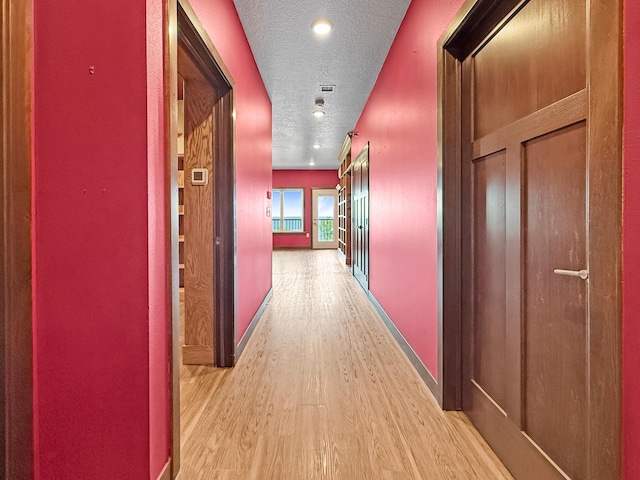 715 Lake Shore Dr NE Unit 214, Bemidji, MN 56601 - corridor with light wood finished floors, a textured ceiling, and baseboards