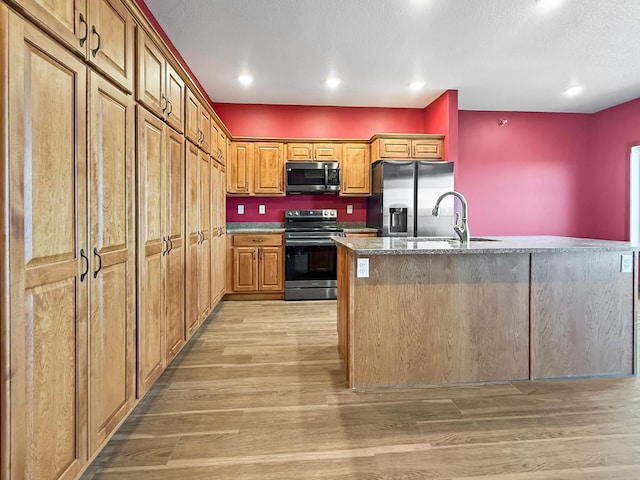 715 Lake Shore Dr NE Unit 214, Bemidji, MN 56601 - kitchen with appliances with stainless steel finishes, a sink, light wood finished floors, stone counters, and brown cabinetry