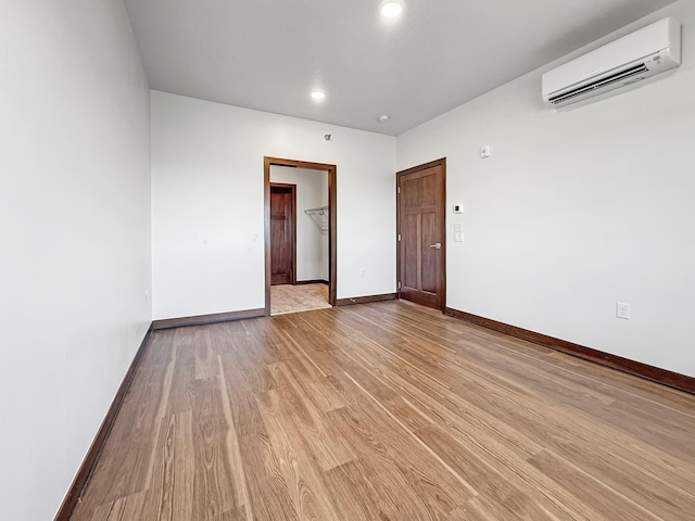 715 Lake Shore Dr NE Unit 214, Bemidji, MN 56601 - unfurnished room with a wall unit AC, light wood-style floors, baseboards, and recessed lighting