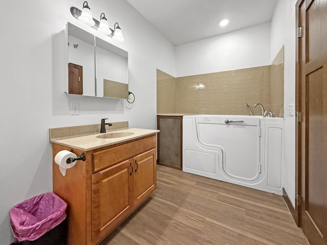 715 Lake Shore Dr NE Unit 214, Bemidji, MN 56601 - bathroom featuring wood finished floors, vanity, a bath, and recessed lighting