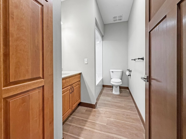 715 Lake Shore Dr NE Unit 214, Bemidji, MN 56601 - bathroom featuring toilet, vanity, wood finished floors, and baseboards