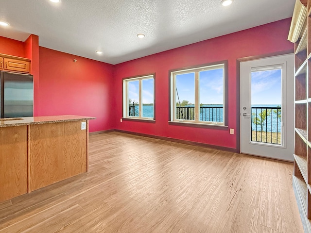 715 Lake Shore Dr NE Unit 214, Bemidji, MN 56601 - unfurnished living room with light wood-style flooring, a textured ceiling, baseboards, and recessed lighting