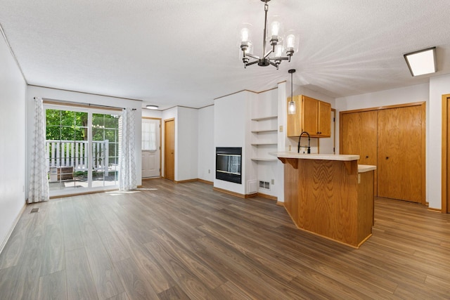8379 Corcoran Cir Unit 47, Inver Grove Heights, MN 55076 - kitchen featuring open shelves, wood finished floors, a peninsula, light countertops, and a textured ceiling