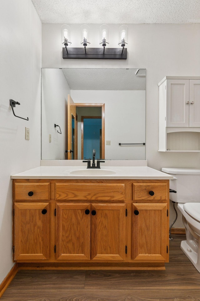 8379 Corcoran Cir Unit 47, Inver Grove Heights, MN 55076 - bathroom featuring vanity, toilet, a textured ceiling, wood finished floors, and baseboards