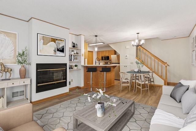8379 Corcoran Cir Unit 47, Inver Grove Heights, MN 55076 - living room with stairway, light wood-style flooring, a chandelier, a glass covered fireplace, and baseboards
