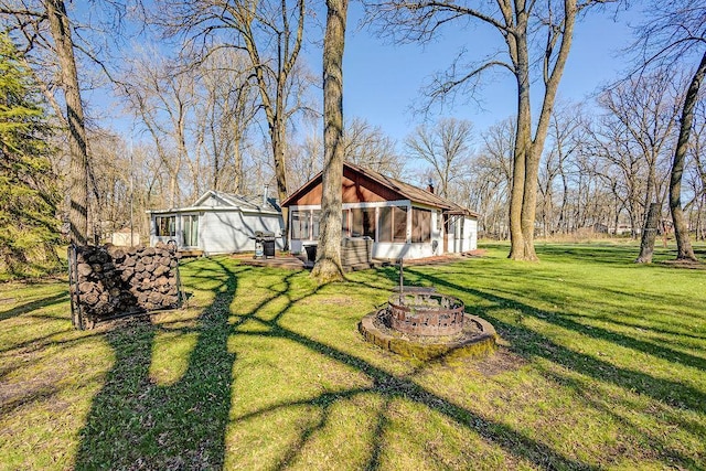 10777 70th St, Clear Lake, MN 55319 - view of green lawn with a fire pit and a sunroom