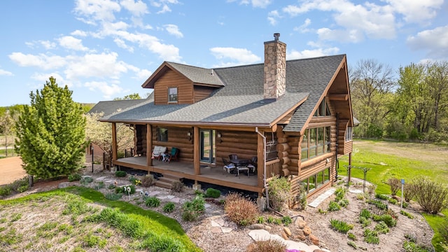 25571 Drexel Ave, New Prague, MN 56071 - rear view of house with log siding, roof with shingles, a chimney, and a deck