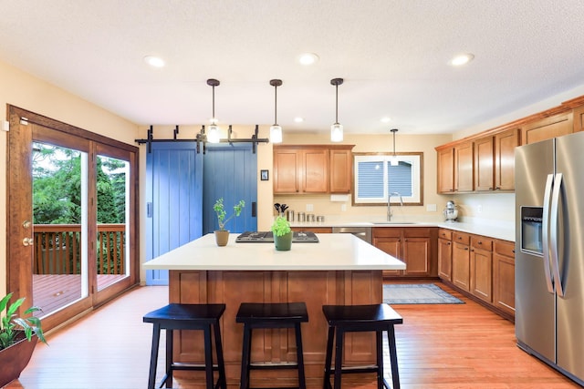 10432 102nd Pl, Maple Grove, MN 55369 - kitchen featuring stainless steel appliances, a sink, a kitchen breakfast bar, light wood finished floors, and a center island