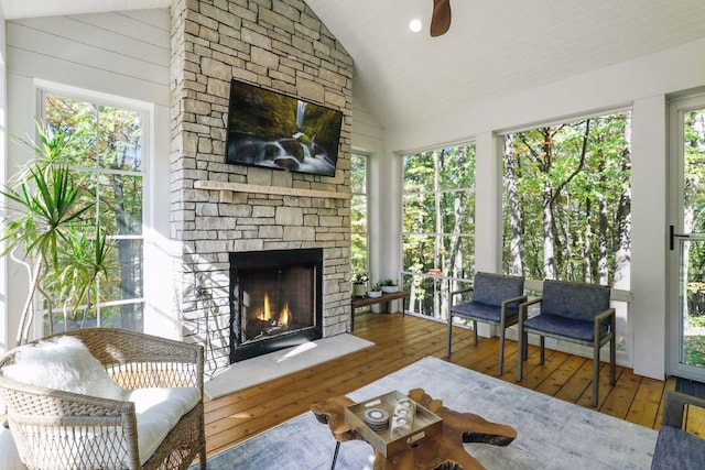 sunroom featuring wood-type flooring and high vaulted ceiling