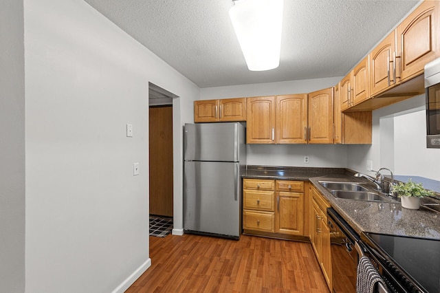 10441 Greenbrier Rd Unit 315, Minnetonka, MN 55305 - kitchen featuring black appliances, a sink, wood finished floors, dark countertops, and baseboards