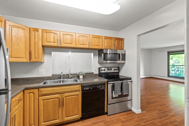 10441 Greenbrier Rd Unit 315, Minnetonka, MN 55305 - kitchen with appliances with stainless steel finishes, a sink, baseboard heating, and dark countertops
