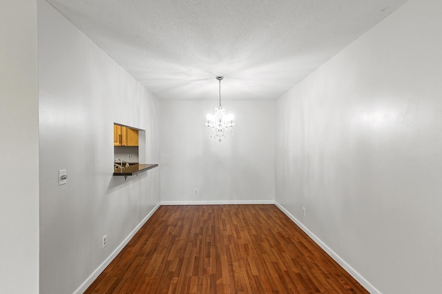 10441 Greenbrier Rd Unit 315, Minnetonka, MN 55305 - unfurnished dining area featuring a chandelier, dark wood-type flooring, baseboards, and a sink