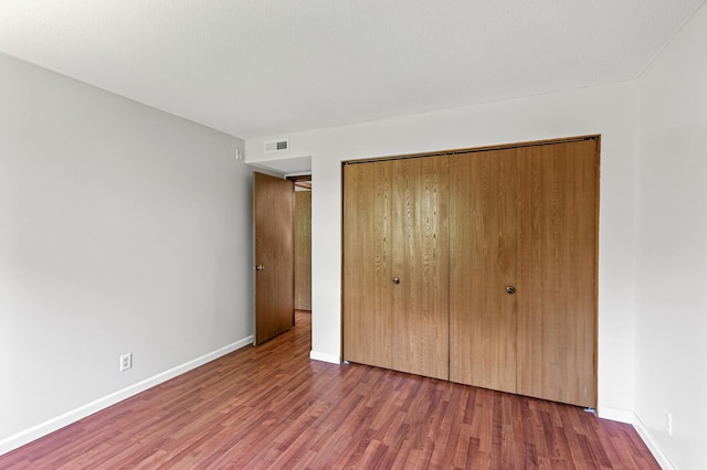 10441 Greenbrier Rd Unit 315, Minnetonka, MN 55305 - unfurnished bedroom featuring wood finished floors, a closet, and baseboards