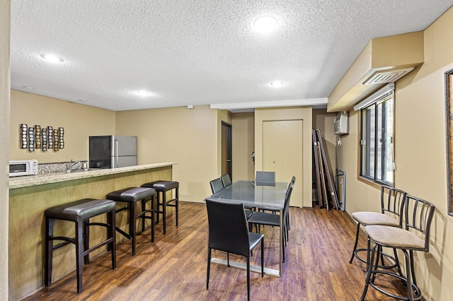 10441 Greenbrier Rd Unit 315, Minnetonka, MN 55305 - dining room featuring a textured ceiling, dark wood-style floors, a bar, recessed lighting, and an AC wall unit