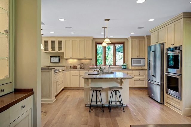 451 Reflection Rd, Apple Valley, MN 55124 - kitchen with stainless steel appliances, light wood-style floors, a kitchen bar, tasteful backsplash, and recessed lighting