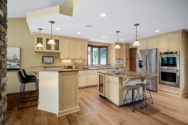 451 Reflection Rd, Apple Valley, MN 55124 - kitchen featuring stainless steel appliances, a breakfast bar, light stone counters, wine cooler, and recessed lighting