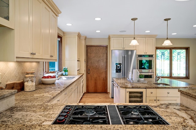 451 Reflection Rd, Apple Valley, MN 55124 - kitchen with appliances with stainless steel finishes, wine cooler, cream cabinetry, light stone counters, and healthy amount of natural light