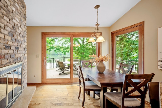 451 Reflection Rd, Apple Valley, MN 55124 - dining space with light wood finished floors, vaulted ceiling, and a fireplace