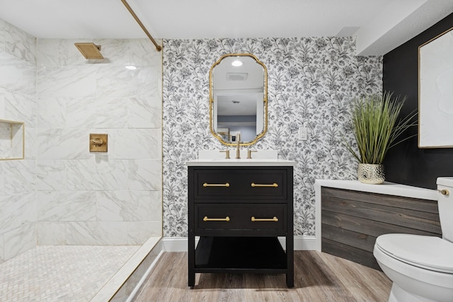 406 Mulberry St W, Stillwater, MN 55082 - bathroom with wood finished floors, vanity, toilet, tiled shower, and wallpapered walls