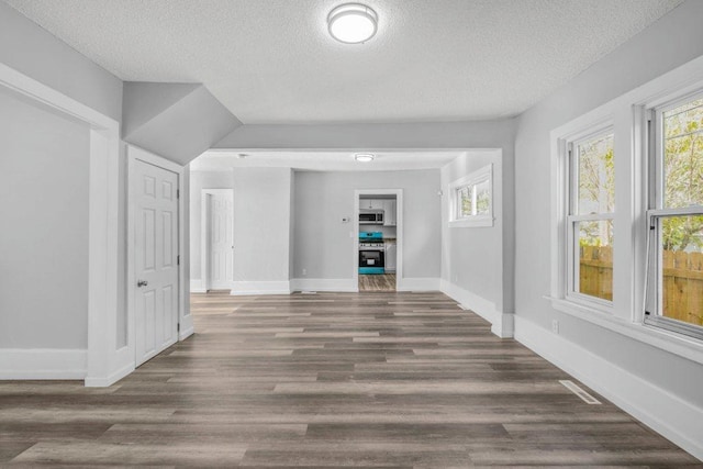 1912 15th Ave N, Minneapolis, MN 55411 - empty room with a textured ceiling, healthy amount of natural light, baseboards, and wood finished floors